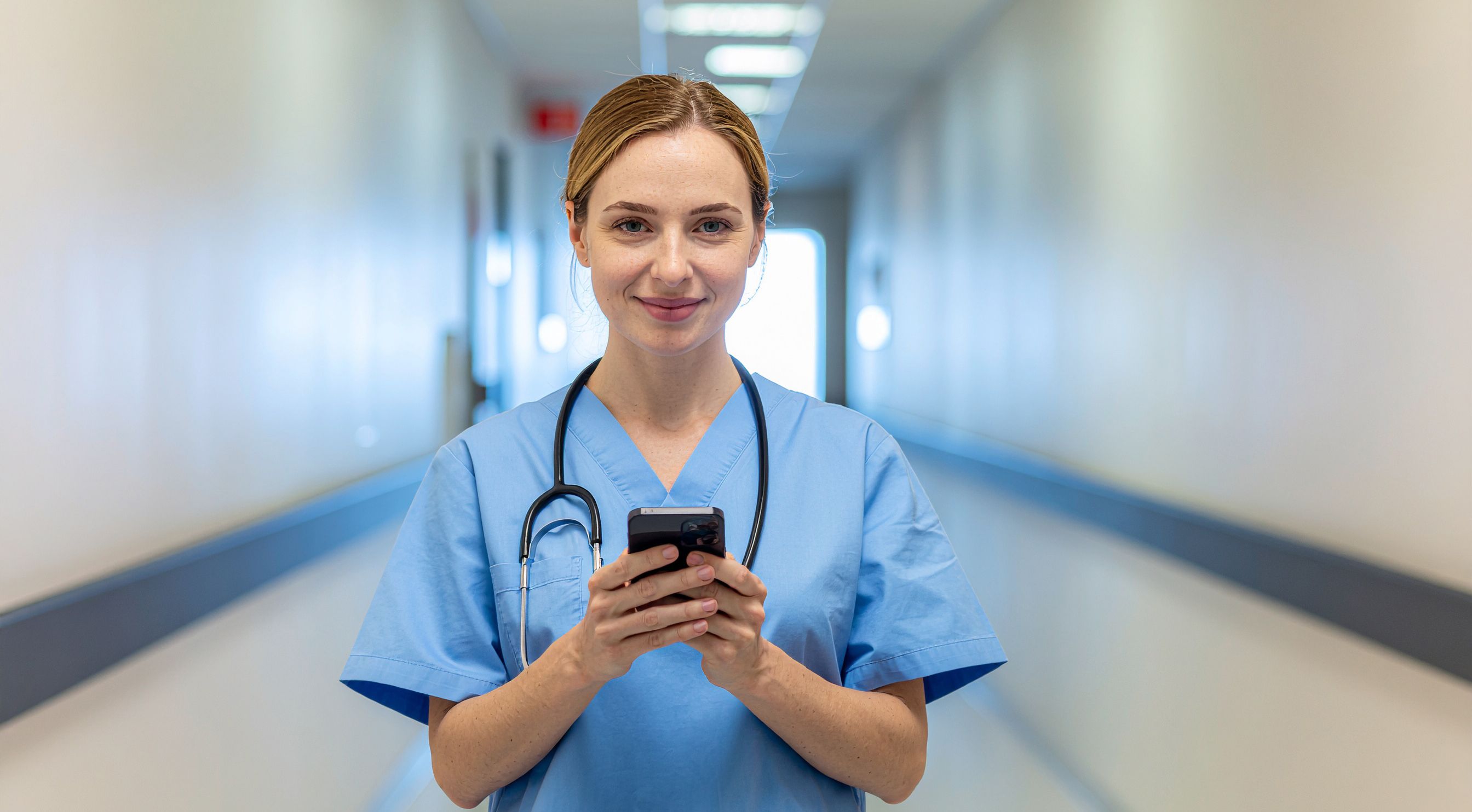 Eine Pflegerin im Krankenhaus bedient ein Smartphone