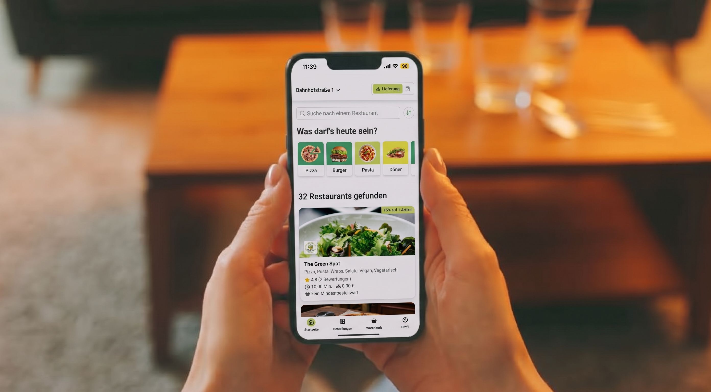Eine Person hält ein Smartphone, darauf die EAT-TAXI-Bestell-App geöffnet.